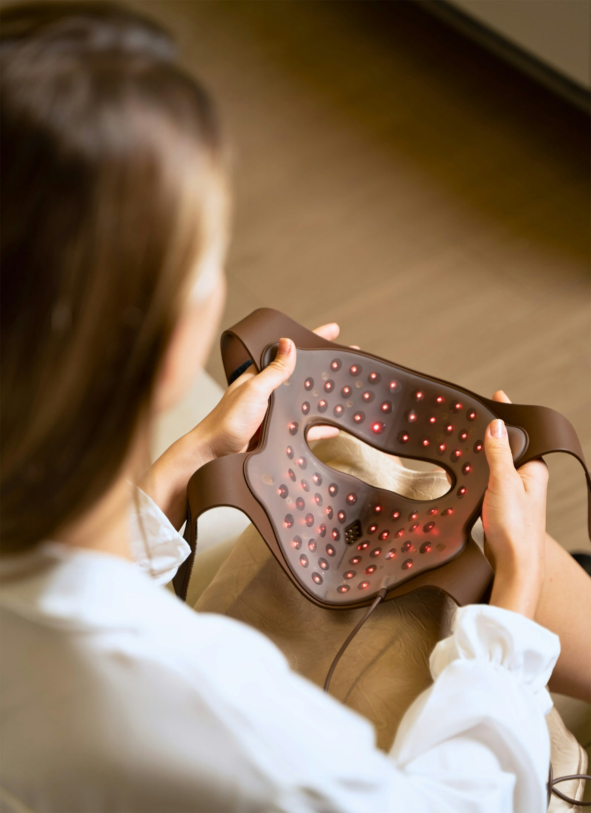A woman sitting on a couch holding a brown bag
