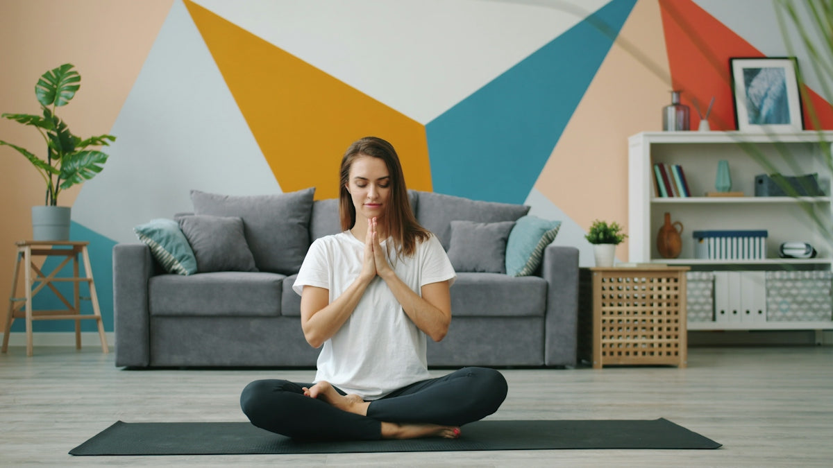 Woman meditating in lotus pose on yoga mat